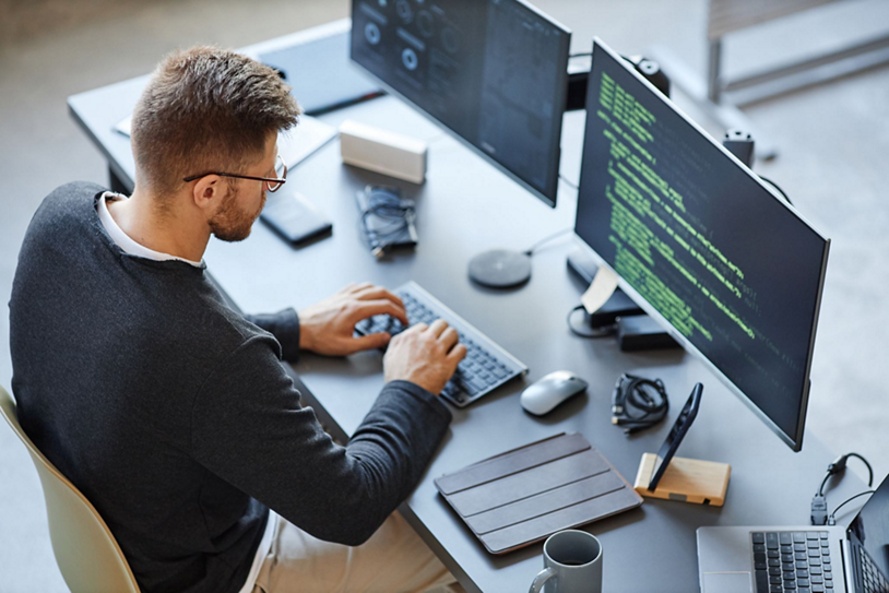 A man uses generative AI on a PC to code.