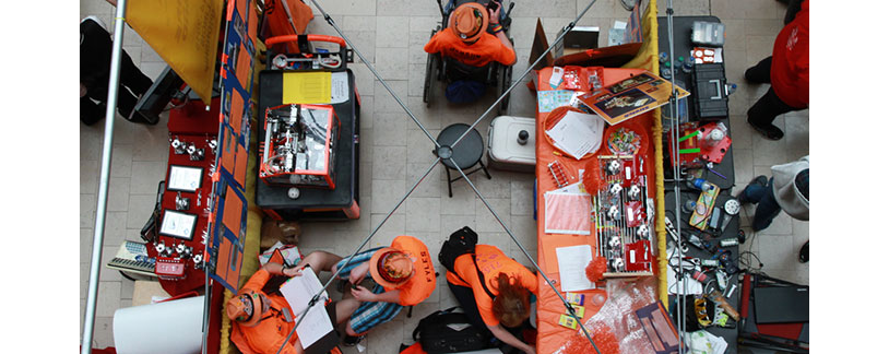 A FIRST Tech Challenge (FTC) team at their booth, surrounded by the tools of the trade.