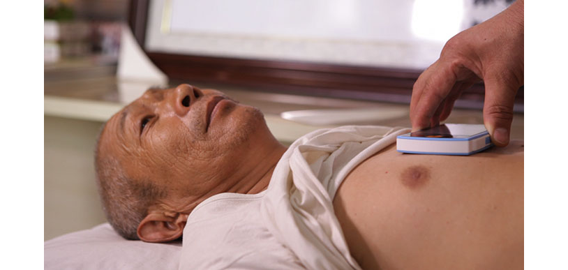 A doctor screening a patient with the ECG-sensing smartphone.