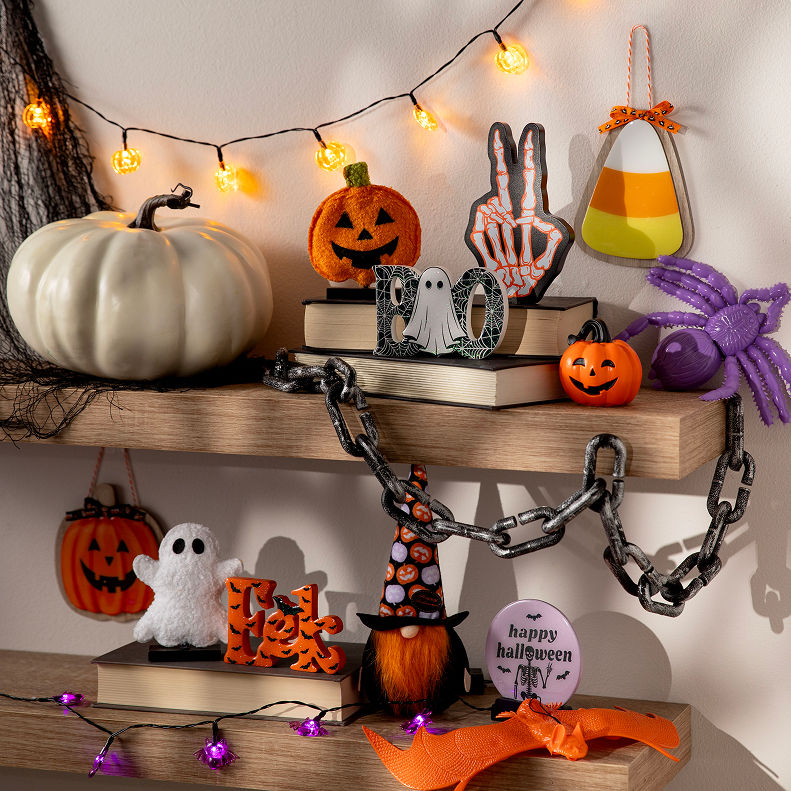 Halloween shelf décor with pumpkins, ghosts, string lights, and seasonal accents