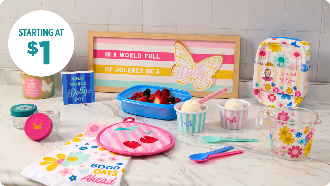Dolly Parton housewares collection with colorful floral kitchen decor, baking tools, storage containers, and inspirational quote sign on marble countertop