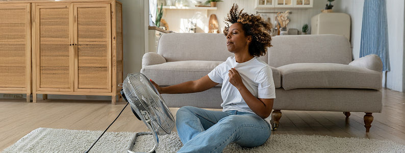 Black woman sitting in front of a fan