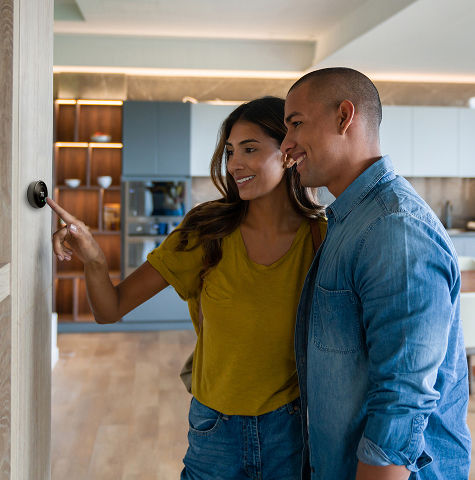 Couple looking at smart thermostat
