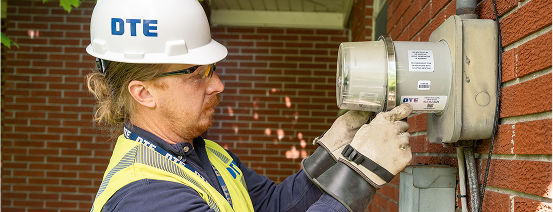 DTE Technician installing Surge Protection Device on a meter on a home