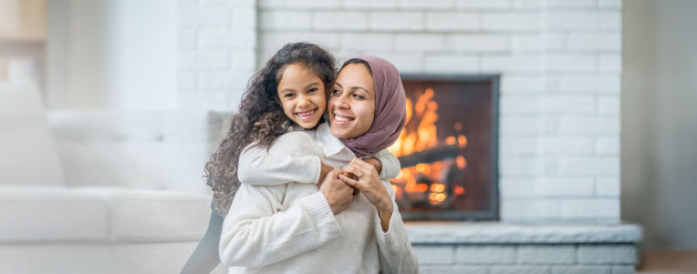 Mother and child in family room with fire place in background