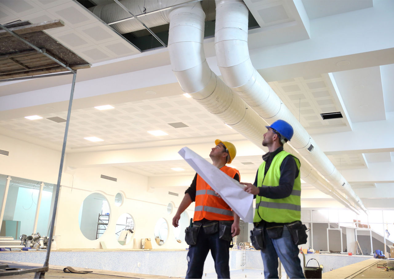 two men discussing DTE HVAC system in a new construction building