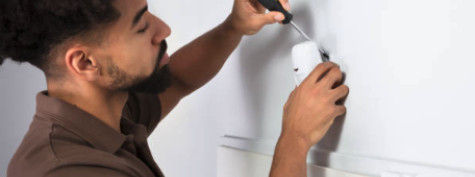 A technician applying a wall motion sensor.