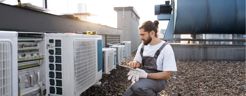 Heating and Cooling contractor checking rooftop cooling system