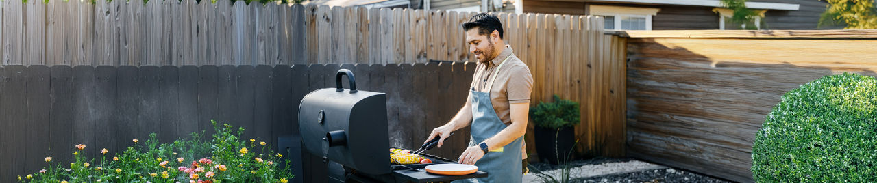 Man cooking on outdoor grill in backyard setting
