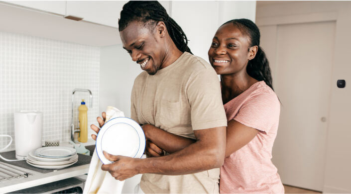 Couple drying dishes smiling