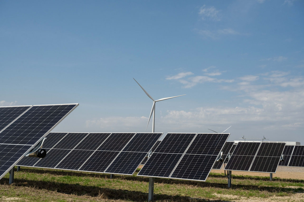 Woman standing in front of images of clean energy sources