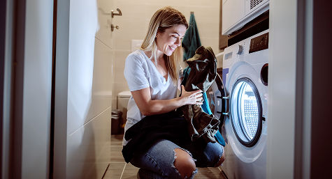 Woman placing clothes into dryer