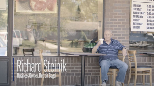 man sitting outside the Detroit Bagel cafe