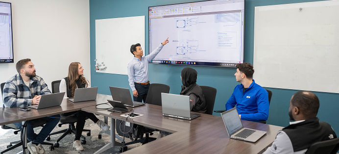 DTE Employees in a meeting reviewing things on a white board.