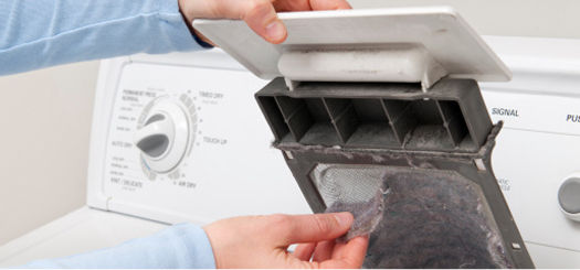 Closeup of hands changing lint filter in clothes dryer.