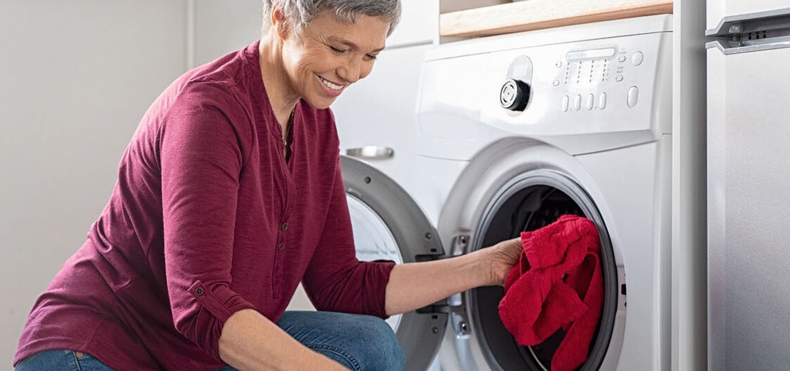 Woman putting clothes in the dryer
