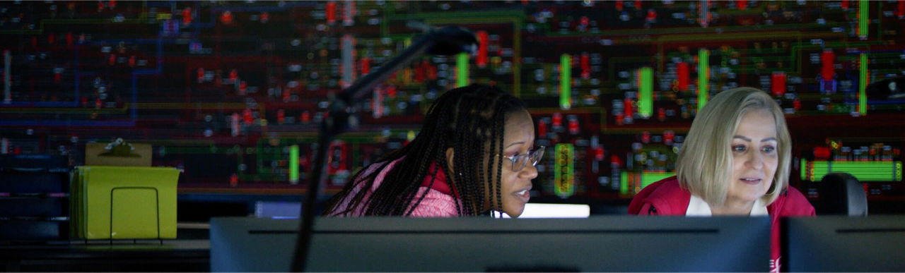 Two women working at DTE's ESOC (Electrical Systems Operations Center)