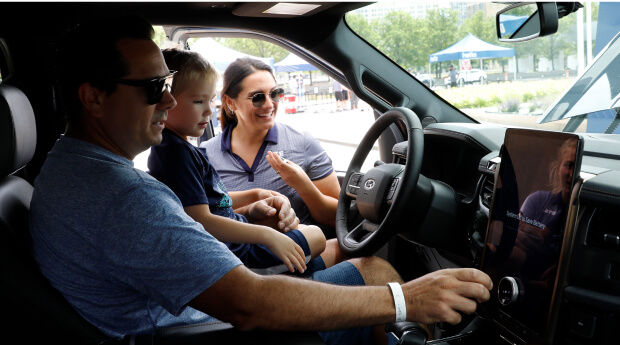 Father and son inside an electric vehicle test driving