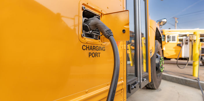 Closeup of an electric school us charging with a DC Fast Charger (DCFC).