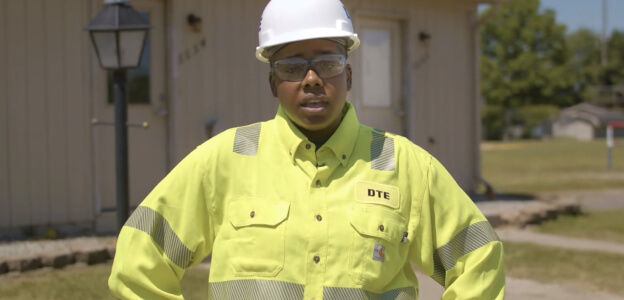 DTE employee looking at camera and wearing a safety yellow top and hard white had