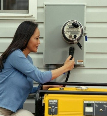 Woman connecting a generator to an electric meter outdoors
