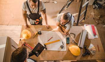 Construction workers looking at plans on a table