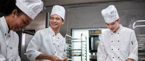 three cooks in a restaurant kitchen