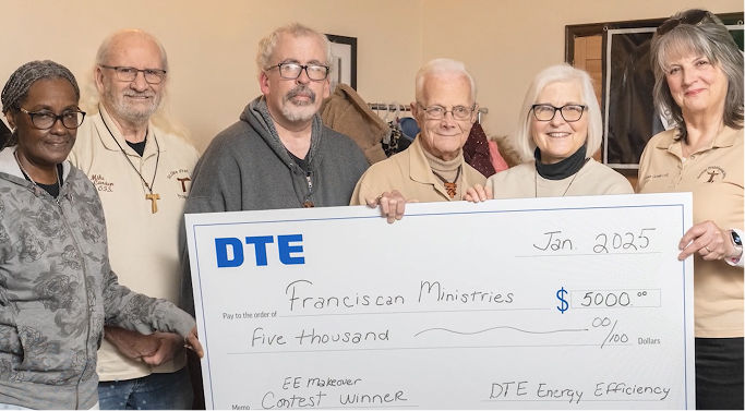 Group of people holding an Energy Efficiency Makeover Contest check made to Franciscan Ministries.