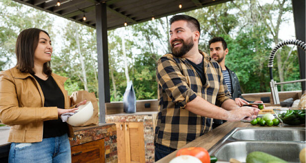 Man talking to a woman while preparing food outdoors 