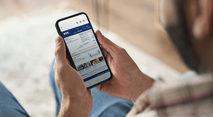 Person using smartphone to view DTE Energy account, billing, and usage details.