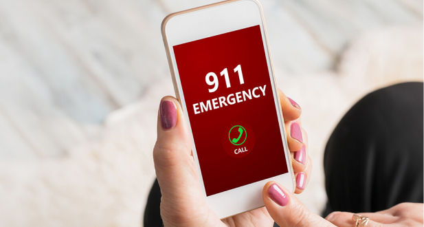 Closeup of hands holding phone and dialing 911