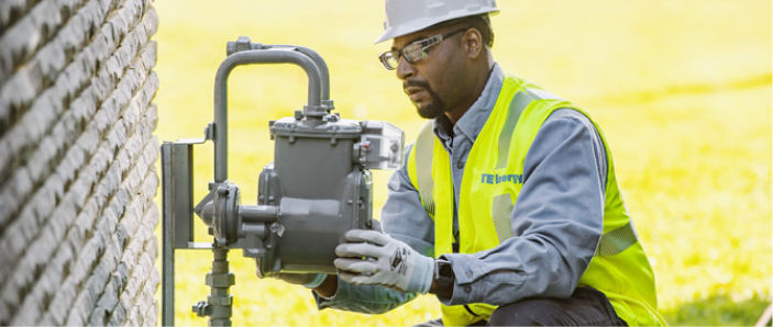 A DTE Energy crew member installing a brand-new natural gas meter at a home.