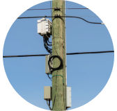 Close up of power supplies, fiber cabinets on utility pole.