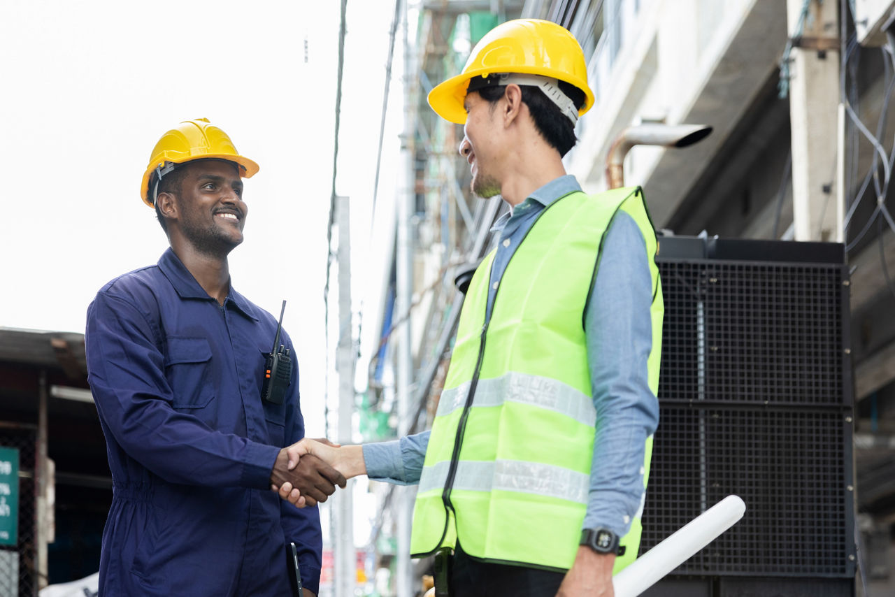 two men shaking hands on a construction site of an energy efficient building