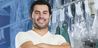 man smiling in a dry cleaner backroom 