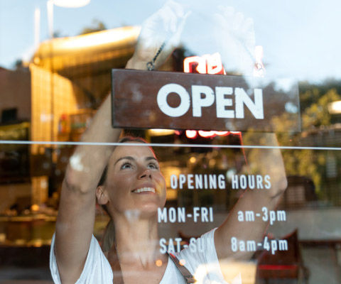 Woman hanging up open sign