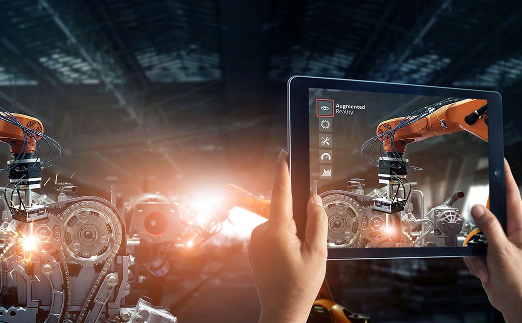 Augmented reality industry concept. Hand holding digital tablet use AR application to check and control welding robotics automatic arms machine in intelligent factory automotive industrial with monitoring system software. Digital manufacturing operation. Industry 4.0
