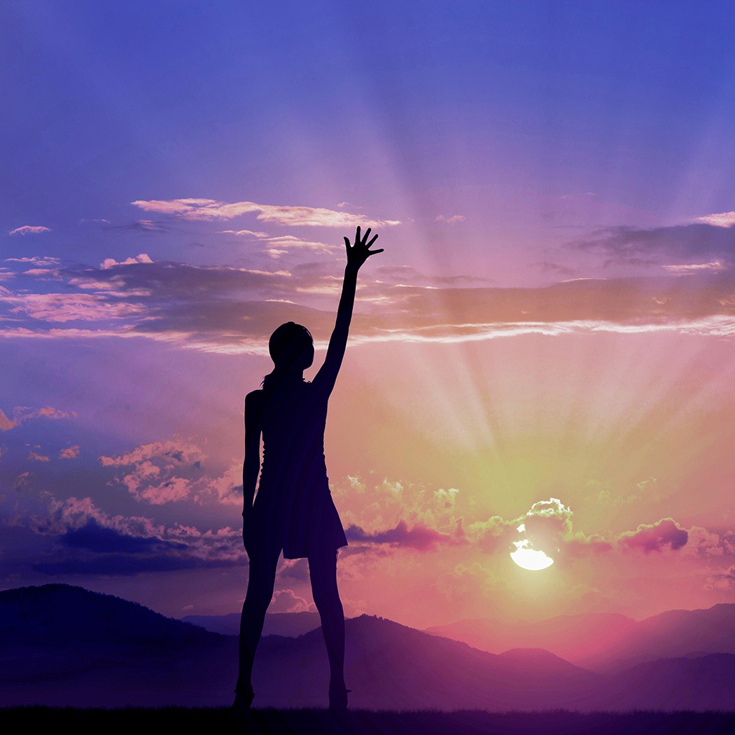 Woman reaching up gazing at brilliant sunset | DXC Technology Insights