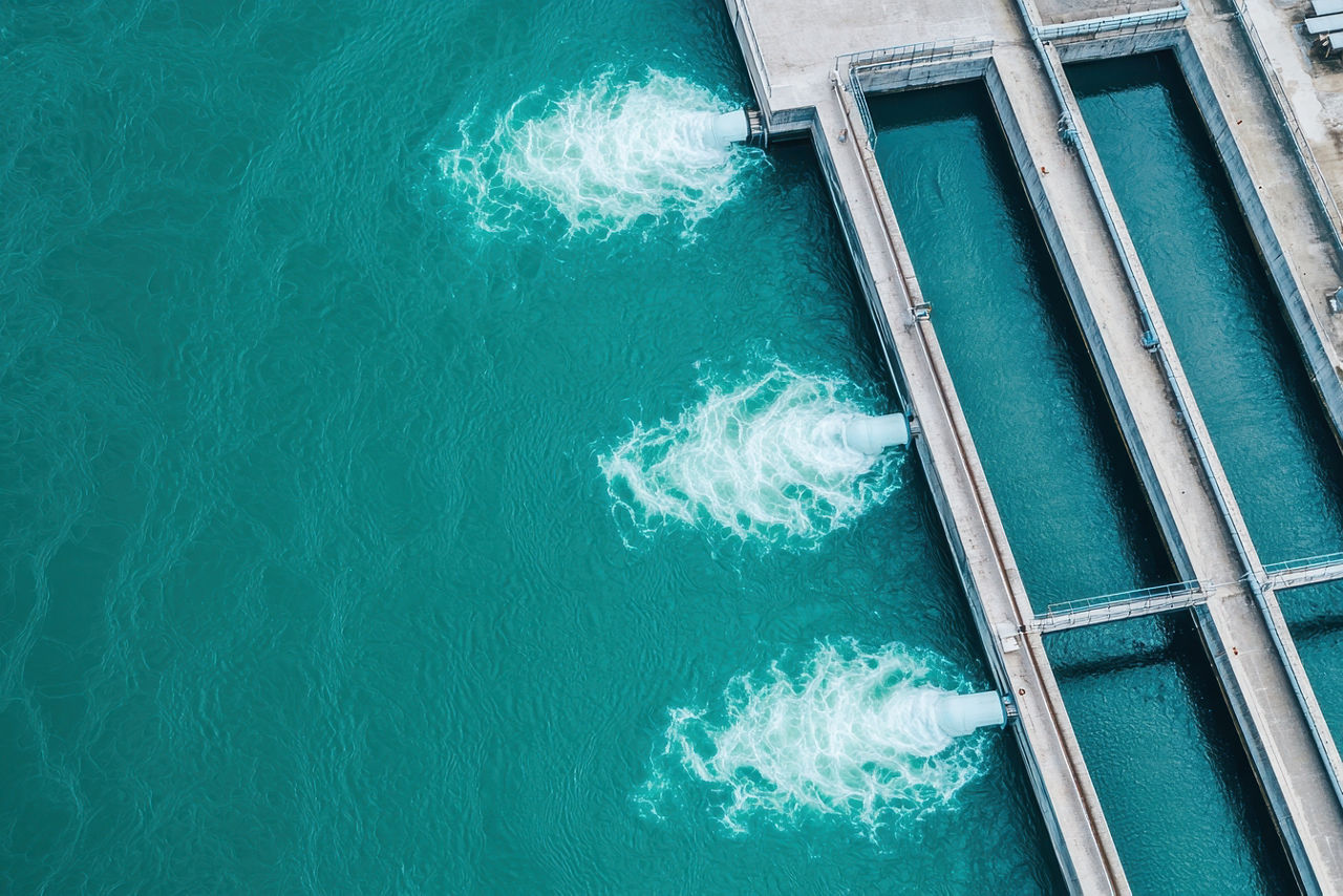 Aerial view of a hydropower plant driving renewable energy and operational efficiency—supported by utility IT services | DXC Technology