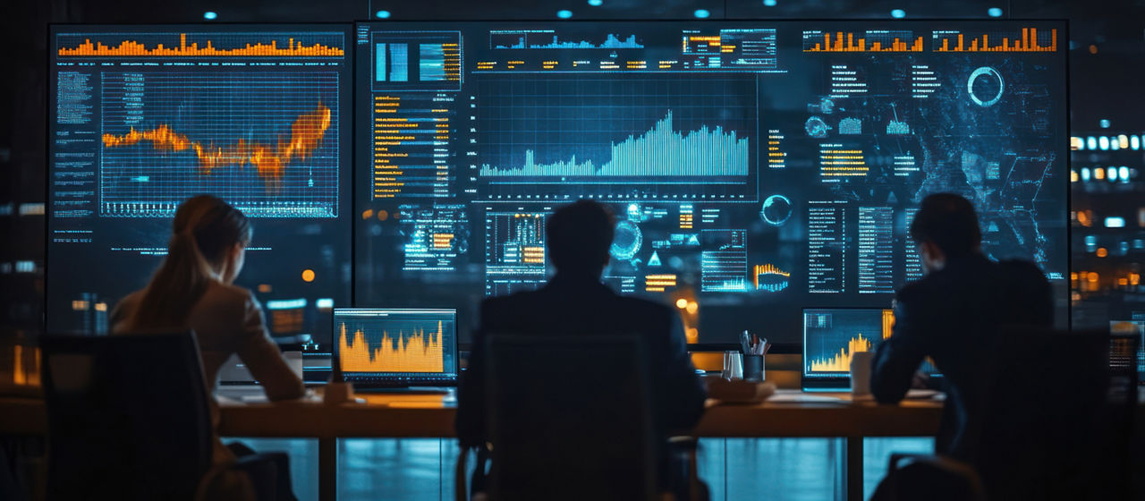 People working on project with screen displaying data, charts - Protecting clients during IT outage| DXC Technology Insights