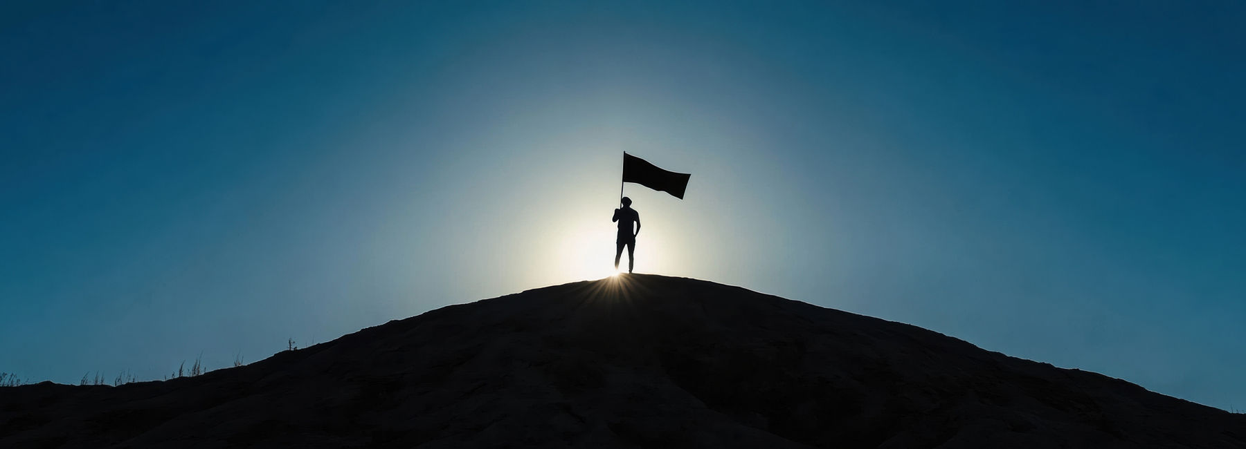 Person atop hill holding flagpole against sunset, Private AI for the Enterprise | DXC Technology Insights