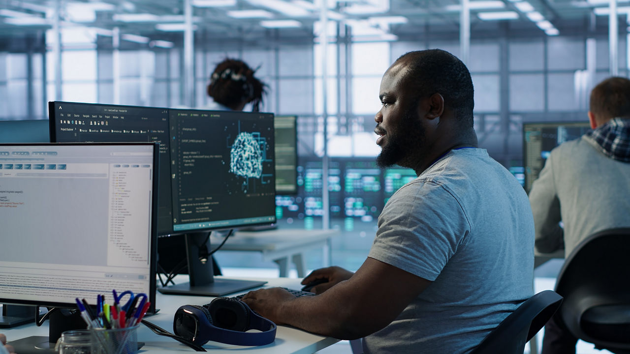 Male data migration engineer working at computer, Snowflake AI Data Cloud | DXC Technology