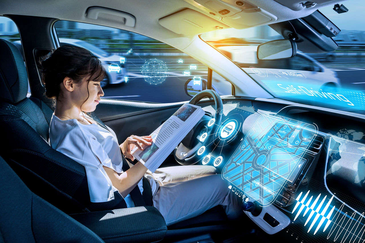 Woman reading in autonomous car,  driver assistance systems ADAS | DXC Technology 