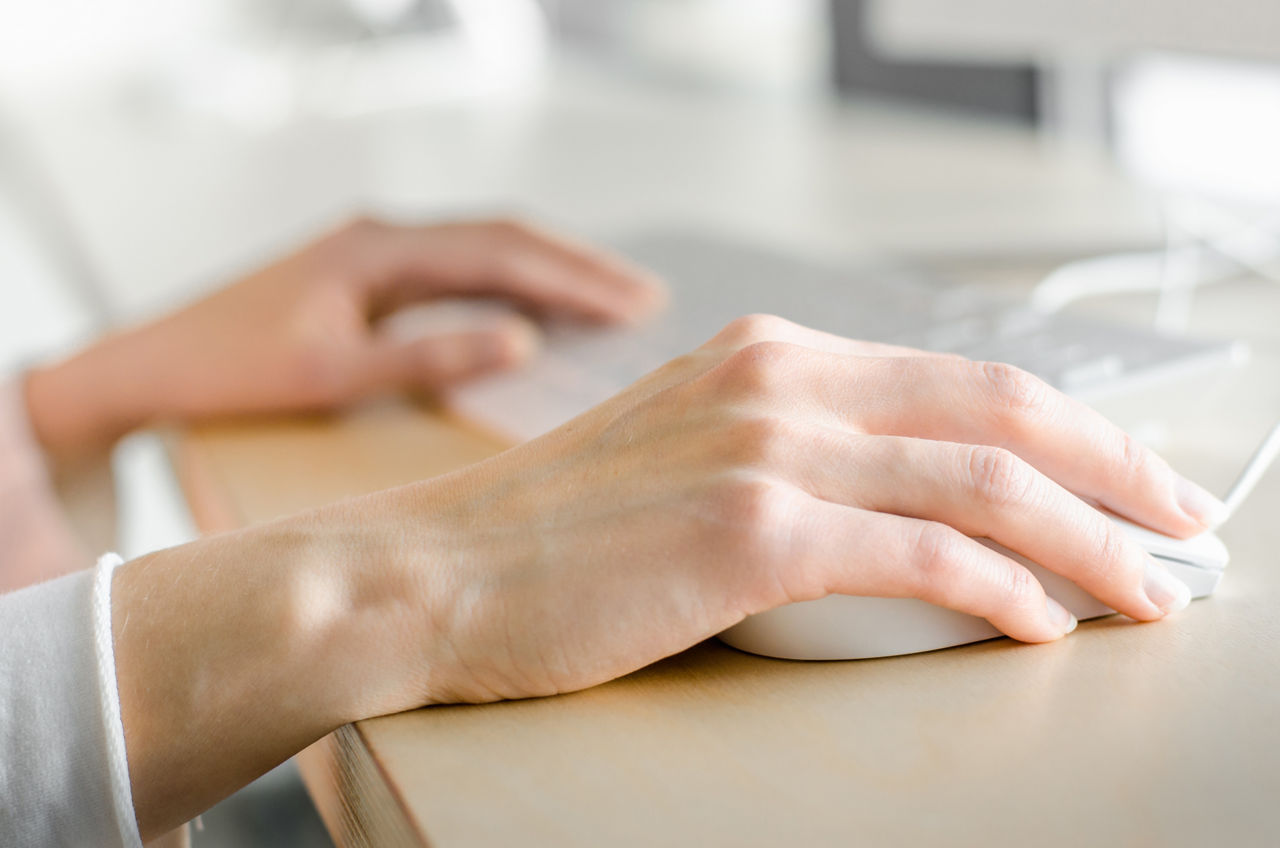 Hands moving mouse near keyboard, Dell Technologies | DXC Technology