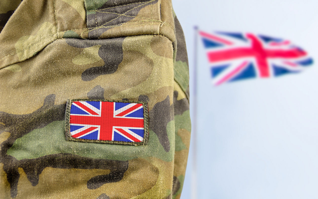 UK soldier's arm with flag in background, Intelligent Collaboration| DXC Technology Customer Story