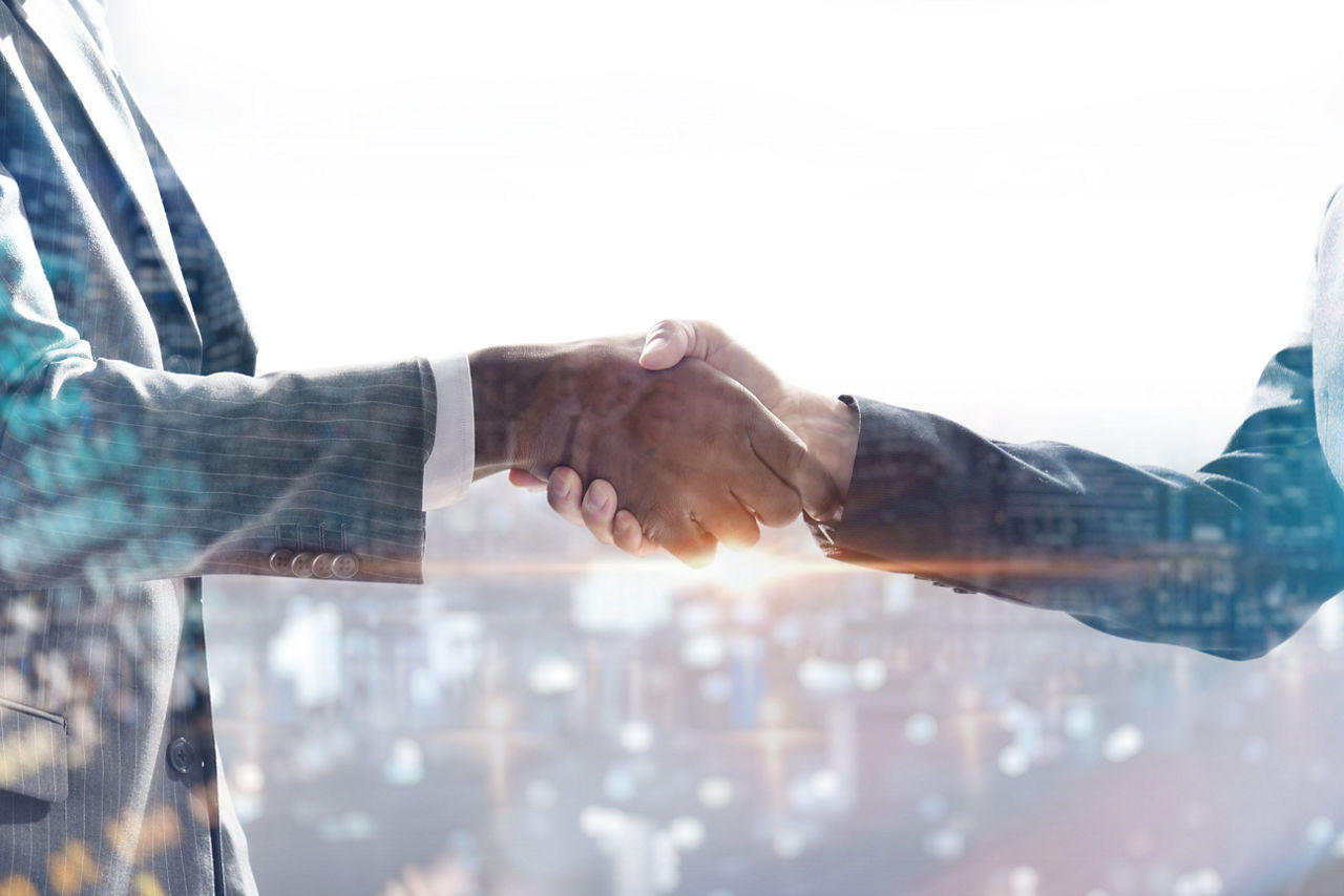 Two people shake hands on software agreement, representing Managed service - Software licensing & Management Solutions | DXC Technology | DXC Technology