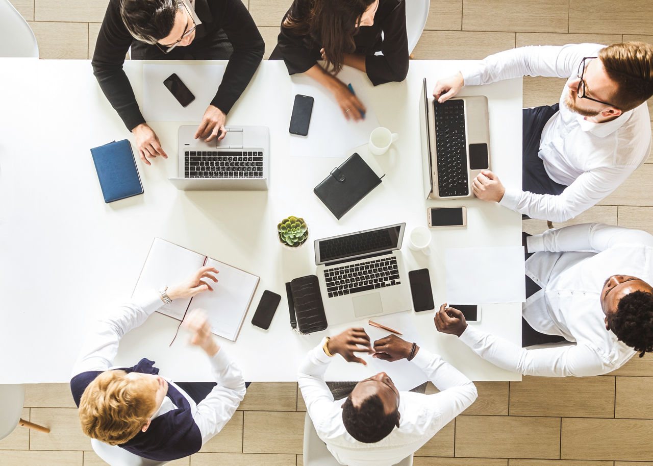 Aerial view of a conference room meeting, highlighting the need for cybersecurity tabletop exercises, Cybersecurity | DXC Technology Insights