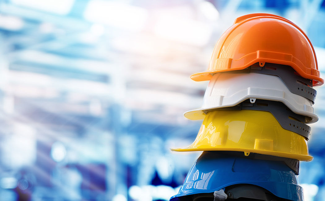 Stack of colorful hardhats, Nordex Group, Consulting & Engineering Services, Manufacturing | DXC Technology Customer Stories