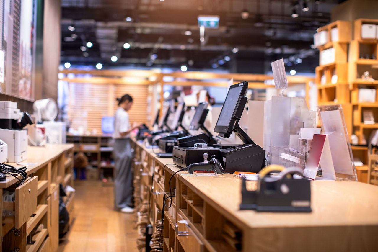 Selective focus to edge of POS machine with blurry cashier staff receive orders from customers at counter service in restaurant or cafe or department store| DXC Technology 
