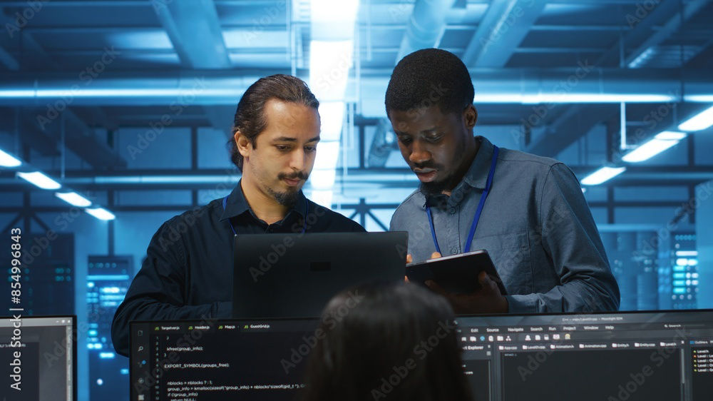 Three IT workers reviewing tech issue, Cloud Migration Services | DXC Technology